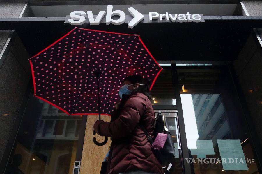 $!Un peatón lleva un paraguas mientras pasa frente a una sucursal privada de Silicon Valley Bank en San Francisco.
