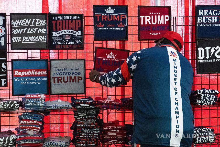 $!Un vendedor ajusta un cartel para una camiseta en apoyo del expresidente Donald Trump en la Conferencia Anual de Acción Política Conservadora.