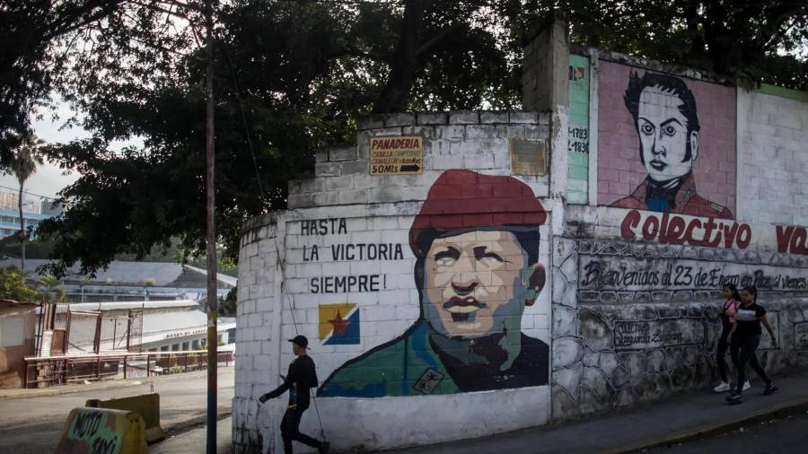 Un hombre camina frente a un mural dedicado al fallecido presidente venezolano Hugo Chávez, en Caracas, Venezuela.