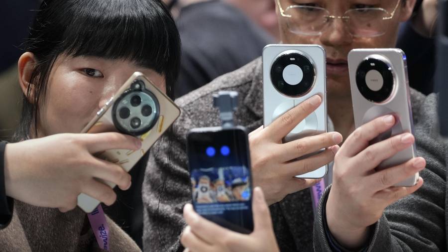 Varios visitantes observan el funcionamiento de la cámara ‘tracking’ para móviles de un teléfono Honor, durante la jornada inaugural de la vigésima edición del Mobile World Congress (MWC) en Barcelona.