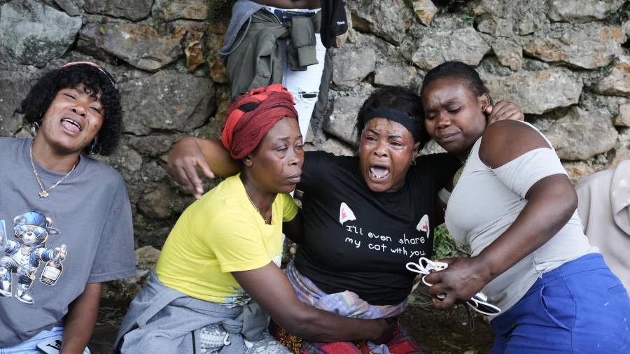 Varias mujeres se lamentan en el lugar donde sus familiares fueron asesinados durante un ataque de pandillas en el barrio de Kenscoff, el lunes 24 de agosto de 2026, en Puerto Príncipe, Haití. (AP Foto/Odelyn Joseph)