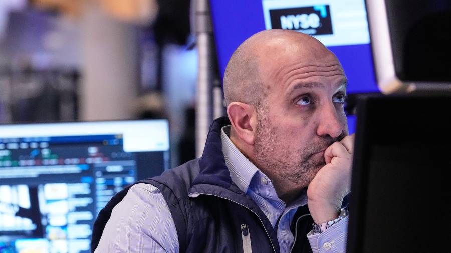 El especialista James Denaro trabaja en su puesto en el piso de la Bolsa de Valores de Nueva York.