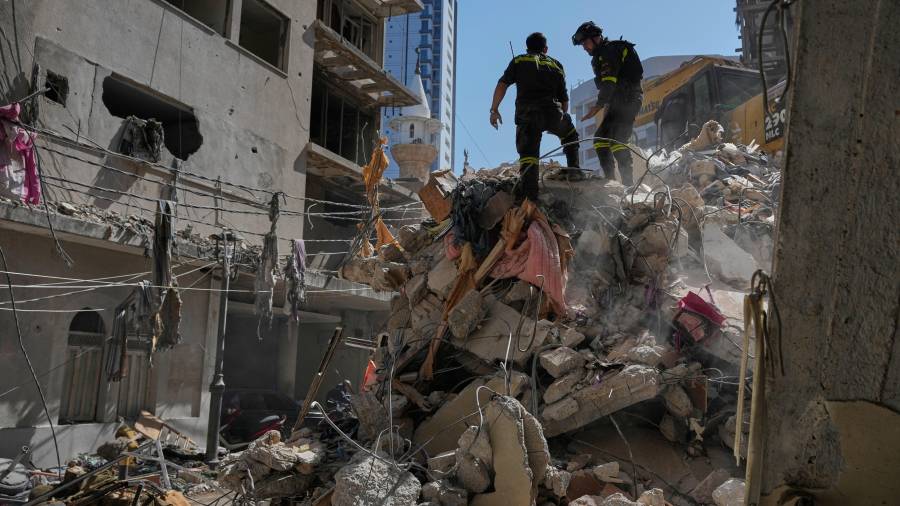 Trabajadores de la defensa civil libanesa inspeccionan los escombros de un edificio destruido por un ataque aéreo israelí el día anterior en Beirut, Líbano.