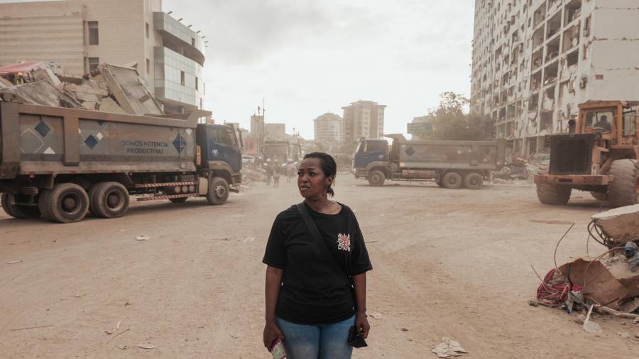 Jacqueline Zúñiga, de 52 años, entre varios complejos de viviendas sociales que se derrumbaron durante el doble terremoto. El edificio de Zúñiga sufrió daños y ahora vive en un refugio improvisado.