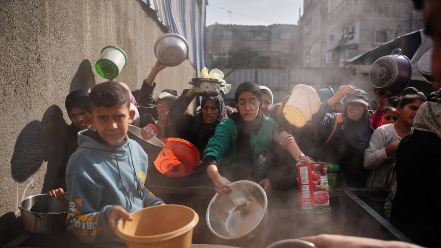 Palestinos reciben alimentos en Nuseirat, Franja de Gaza.