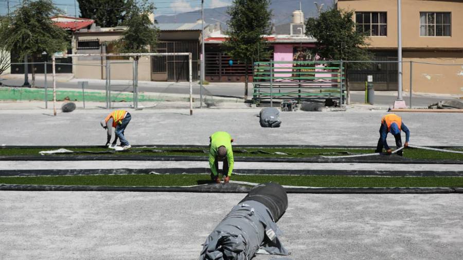 Trabajadores preparan la cancha de fútbol rápido del Parque Lineal para la colocación de pasto artificial.