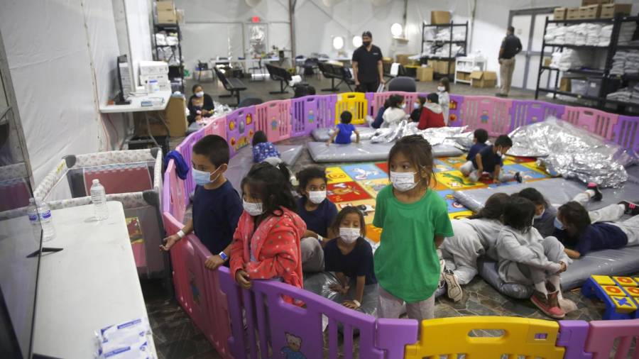 30 de marzo de 2021. Niños migrantes no acompañados ven la televisión dentro de un corralito en el centro de detención de la Oficina de Aduanas y Protección Fronteriza en Donna, Texas.