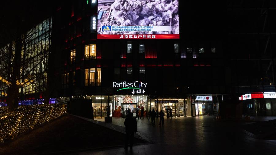 La gente mira una transmisión en una pantalla en un centro comercial sobre los ataques aéreos estadounidenses e israelíes en Irán y el contraataque de Irán, en Beijing, China.