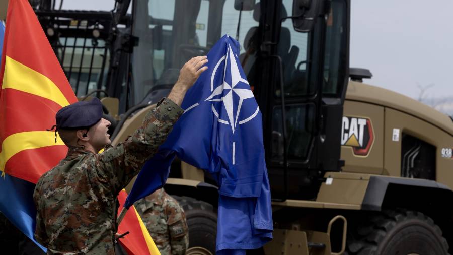 SKOPJE (North Macedonia), 03/07/2026.- A North Macedonia's soldier adjusts the NATO flag during the event of the promotion of new military equipment at Ilinden Barracks in Skopje, Republic of North Macedonia, 03 July 2026. As part of cooperation with the European Union and with support from the European Peace Facility, equipment worth more than 40 million euros has been procured in three packages; items from the first package and part of the second have already been delivered to the country. The equipment includes various assets—radars, thermal cameras, transport vehicles, simulators, a 3D radar system, and portable sensors—while the third package will provide equipment for logistics, communications, and infantry units. EFE/EPA/GEORGI LICOVSKI