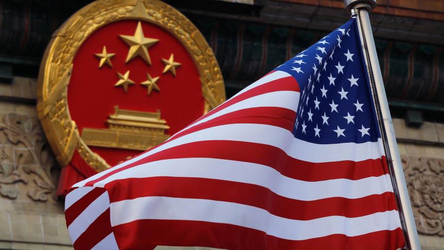 Una bandera estadounidense ondea junto al emblema nacional chino durante una ceremonia de bienvenida a Donald Trump, de visita en China, frente al Gran Salón del Pueblo en Pekín, el 9 de noviembre de 2017.