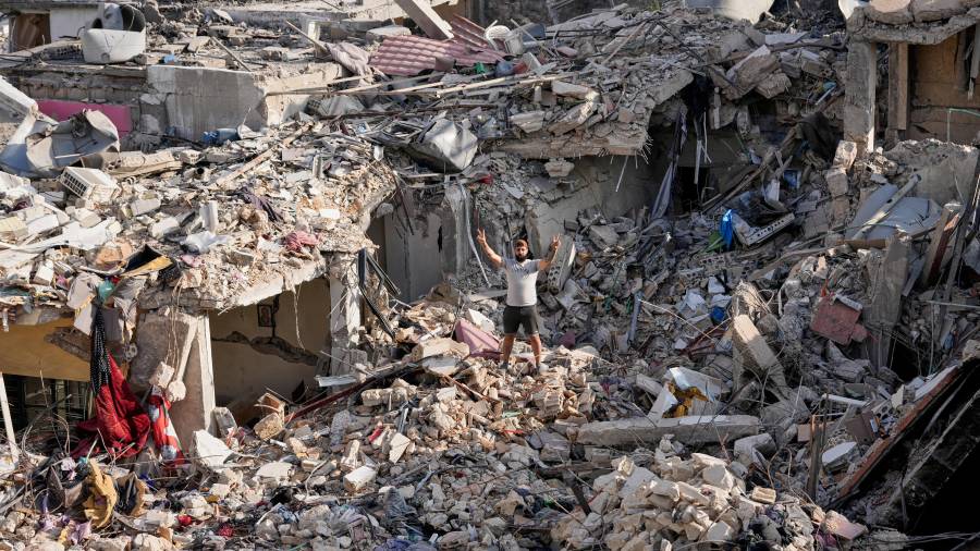 Un hombre que regresa a su aldea tras el anuncio de un acuerdo de alto el fuego entre EU e Irán, hace el signo de la victoria mientras permanece de pie sobre los escombros de su casa destruida en Nabatiyeh, Líbano.