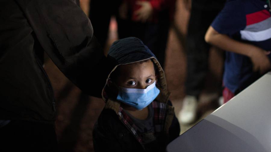 Un menor no acompañado levanta la vista mientras espera responder a las preguntas de un agente de la Patrulla Fronteriza en un centro de recepción, el 24 de marzo de 2021, en Roma, Texas.
