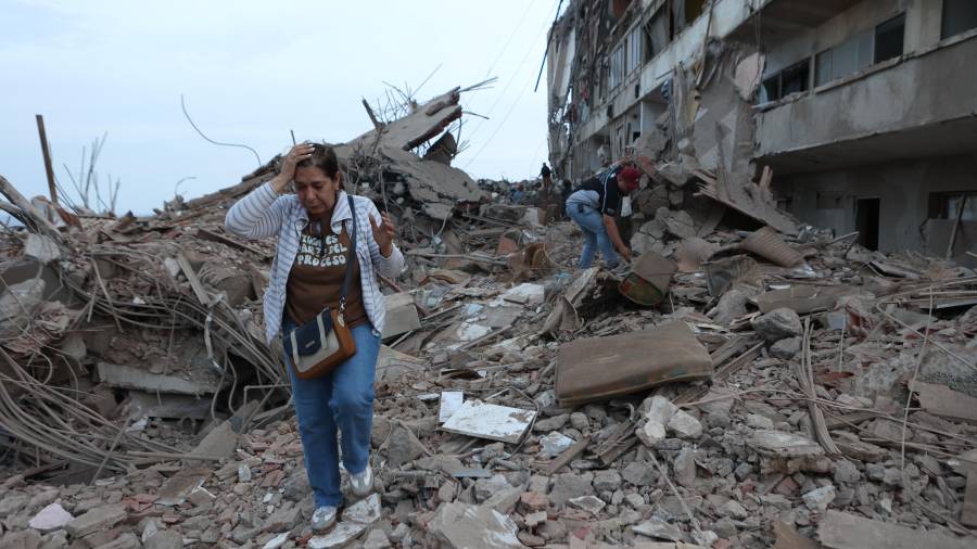Residentes caminan entre los escombros de edificios dañados por los terremotos del día anterior en Catia La Mar, Venezuela, el jueves 25 de junio de 2026.