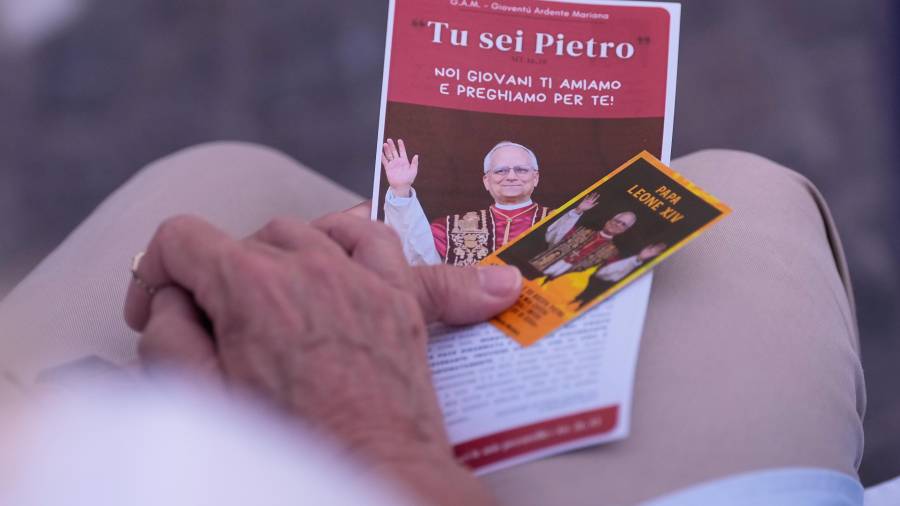 Una mujer sostiene fotografías del papa León XIV mientras reza en el Policlínico Agostino Gemelli, donde el pontífice se encuentra hospitalizado, en Roma, el jueves 15 de octubre de 2026.