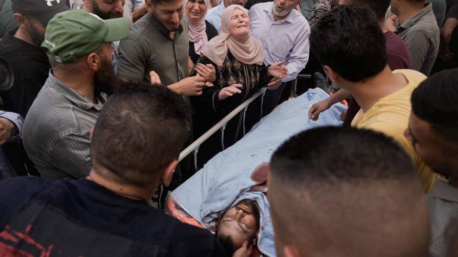 Varias personas lloran sobre el cuerpo de Jawad Ramadan, quien fue asesinado por fuerzas israelíes cerca de la localidad de Tell, luego de que su cuerpo fue trasladado a un hospital de la ciudad cisjordana de Nablus.