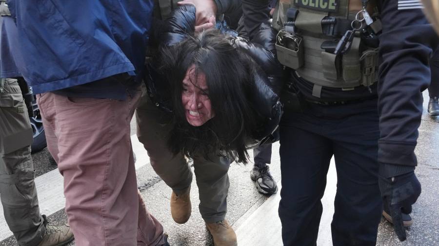 Agentes federales detienen a una persona durante una protesta contra las redadas migratorias el martes 13 de enero de 2026, en Minneapolis.