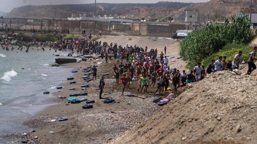 Migrantes cruzan el jueves 30 de julio de 2026 desde Marruecos hacia el enclave español de Ceuta.