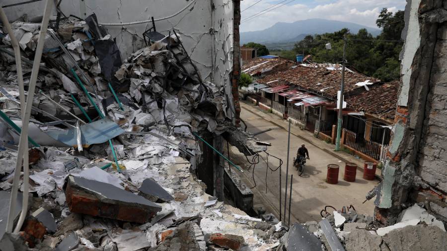 Un hombre pasa en motocicleta junto a las ruinas de casas destruidas cinco meses antes en un ataque de disidentes de las antiguas Fuerzas Amadas Revolucionarias de Colombia en Buenos Aires, Cauca, Colombia.