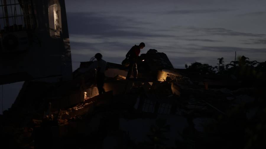 Miembros de los servicios de emergencia revisan los escombros en busca de víctimas tras los terremotos, en la localidad de Catia La Mar, en el estado costero de La Guaira, Venezuela este jueves.