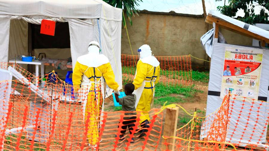 Trabajadores sanitarios acompañan a un niño sospechoso de tener ébola en el centro de tratamiento de la enfermedad en Beni, en el este de República Democrática del Congo, el 9 de septiembre de 2018.