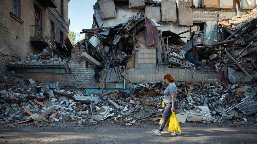 Una mujer pasa junto a los restos de edificios destruidos en Slaviansk, en la región de Donbass en Ucrania, el 14 de septiembre de 2025.