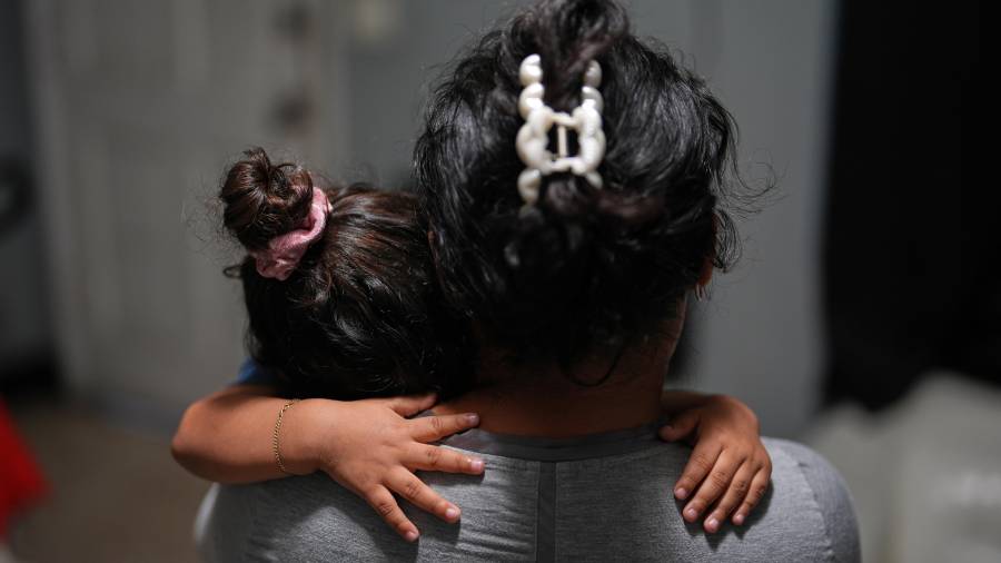 Yaoska, una solicitante de asilo embarazada, consuela a su hijo de dos, que no se siente bien, en la habitación de motel en la que ella y sus hijos viven en la zona de Miami desde que su esposo fue deportado a Nicaragua.