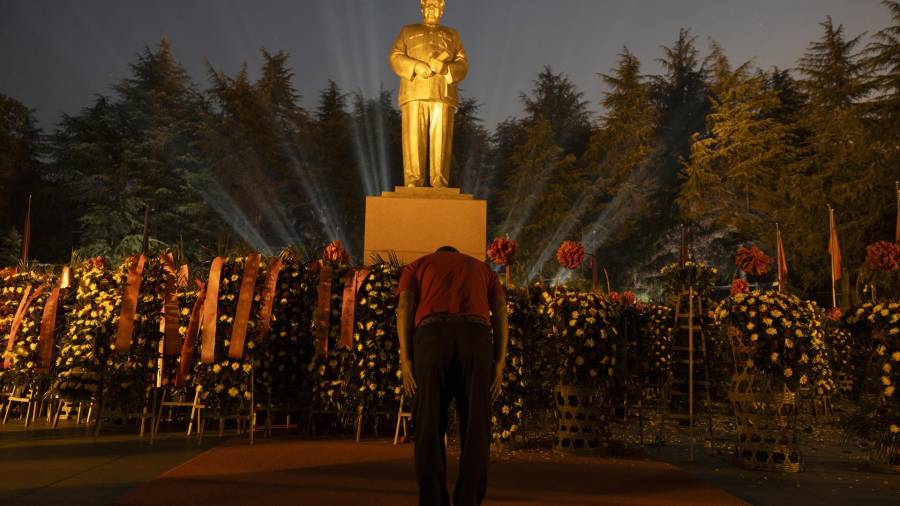 Un hombre se inclina ante la estatua de bronce de Mao Zedong en Shaoshan, provincia de Hunan, en el centro de China.
