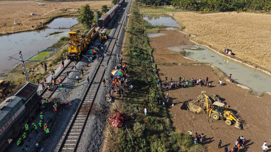 Una excavadora excava un hoyo para enterrar el cadáver de un elefante asiático salvaje que fue retirado de las vías del tren después de que un tren a toda velocidad atropellara a una manada de elefantes en la India.
