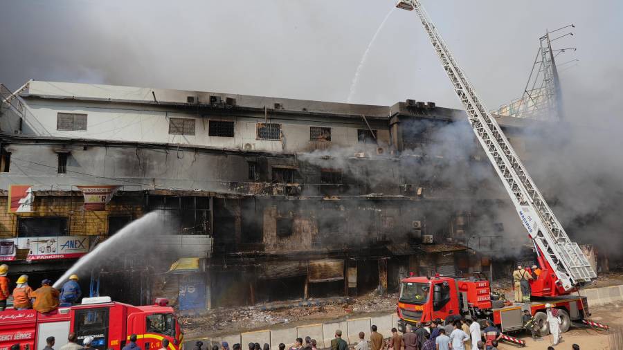 Los bomberos intentan controlar un gran incendio en un centro comercial de varias plantas, en Karachi, Pakistán, el domingo 18 de enero de 2026. FOTO: