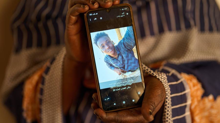 Sulafa Mustafa muestra una fotografía de su hijo desaparecido, Suleiman Abdelsaid, en Omdurman, Sudán.