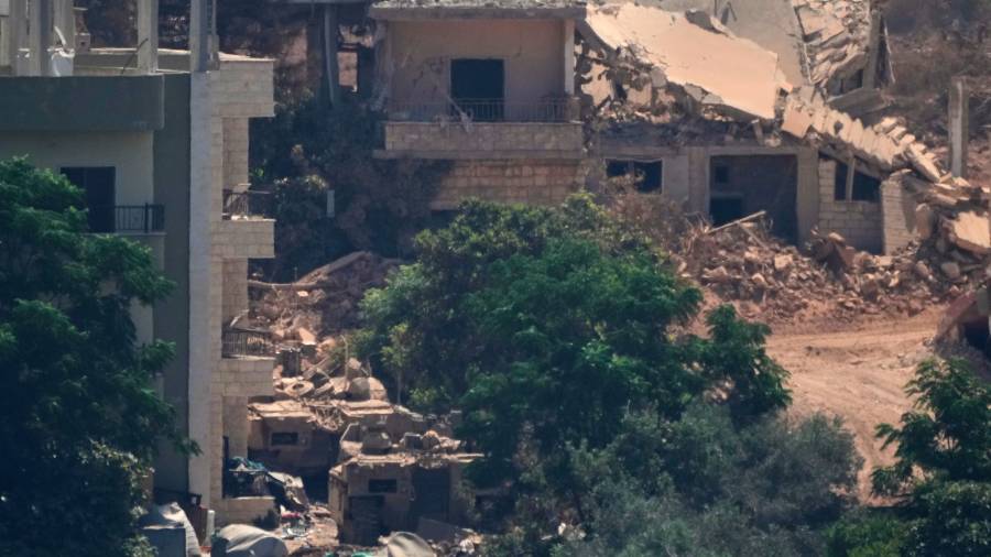 Vehículos militares israelíes (a la izquierda) yacen apostados entre viviendas en la localidad de Zawtar al-Sharqiyah —ocupada por fuerzas israelíes—, en esta fotografía captada desde el pueblo de Zawtar al-Gharbieh.