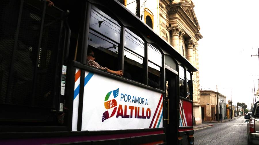El tranvía recorre calles mojadas del Centro Histórico mientras pasajeros observan la ciudad entre luces y reflejos tras la lluvia.