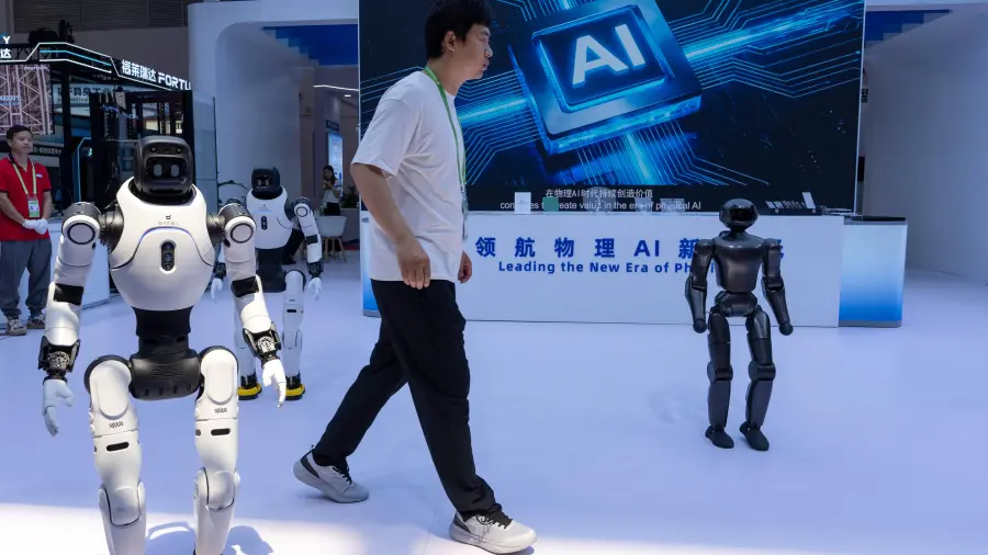 Un trabajador pasa junto a robots de la empresa china Lens en el China International Supply Chain Expo en Beijing, el 22 de junio de 2026.
