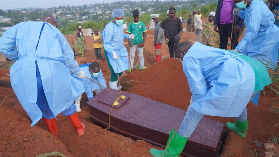 Varias personas con equipos de protección colocan un ataúd con los restos de Baudjo Baraka Jules, de 6 años y que murió de ébola, en una tumba, en Bunia, en la provincia de Ituri, República Democrática del Congo.