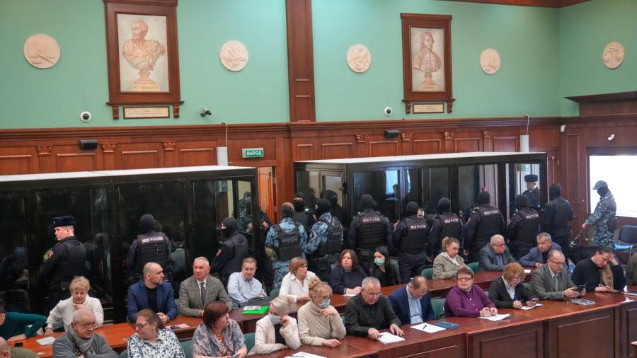 Hombres acusados de implicación en un ataque en la sala de conciertos Crocus City Hall en marzo de 2024 escuchan e veredicto en una celda de cristal en la Corte Militar del Segundo Distrito Occidental en Moscú.