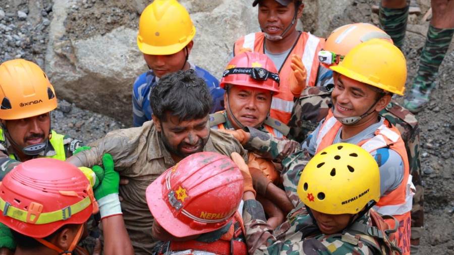 En esta imagen, distribuida por el ejército de Nepal, soldados rescatan con vida a un trabajador atrapado en un túnel durante una operación en el proyecto hidroeléctrico Trishuli-3A en el distrito de Rasuwa, en Nepal.