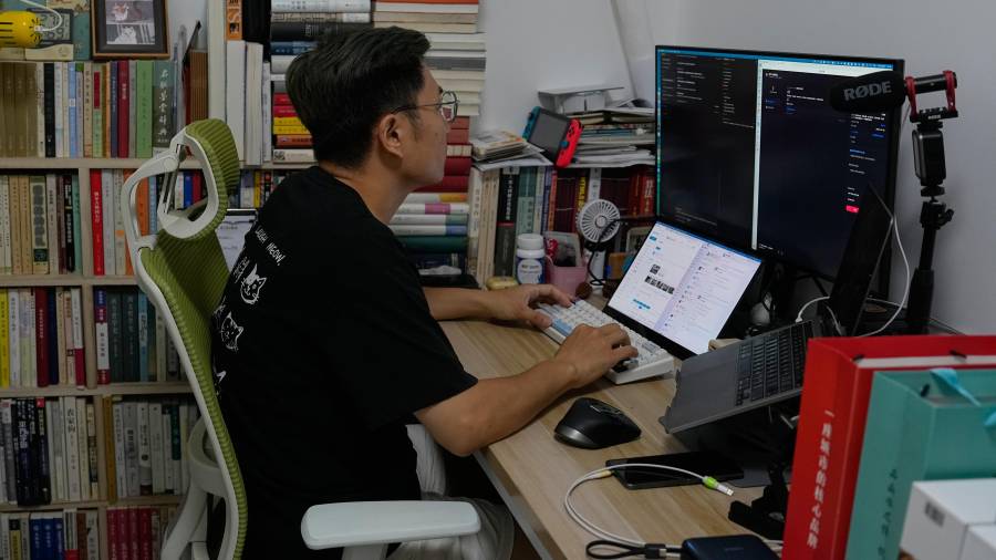 Fei Zhaojun, quien fuera ingeniero de software, trabaja en la computadora de su residencia, el 13 de julio de 2026, en Beijing.