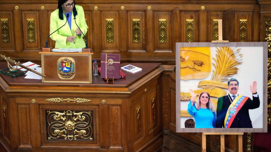 La presidenta encargada de Venezuela, Delcy Rodríguez, habla ante los legisladores junto a una foto del expresidente Nicolás Maduro y su esposa Cilia Flores, en la Asamblea Nacional en Caracas, Venezuela.