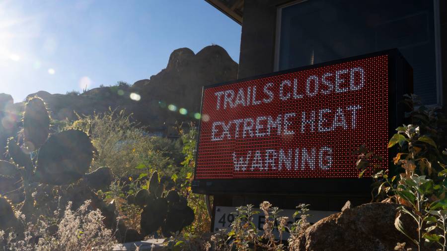 Un letrero avisa que un sendero para excursionistas está cerrado debido al exceso de calor, en la montaña Camelback en Phoenix, Arizona.