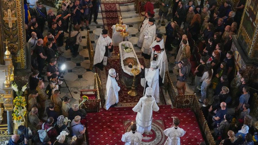 Sacerdotes ofician la ceremonia de despedida de Oleksiy Yukov, quien murió cuando exhumaba los cadáveres de soldados caídos en el frente de la región de Donetsk, en la catedral de San Vladimiro de Kiev.