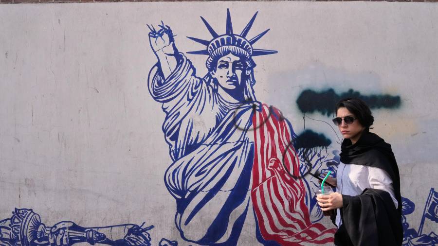 Una mujer pasa junto a un mural antiestadounidense en la pared de la antigua embajada de Estados Unidos, ahora museo, en Teherán, Irán, el viernes 12 de junio de 2026.