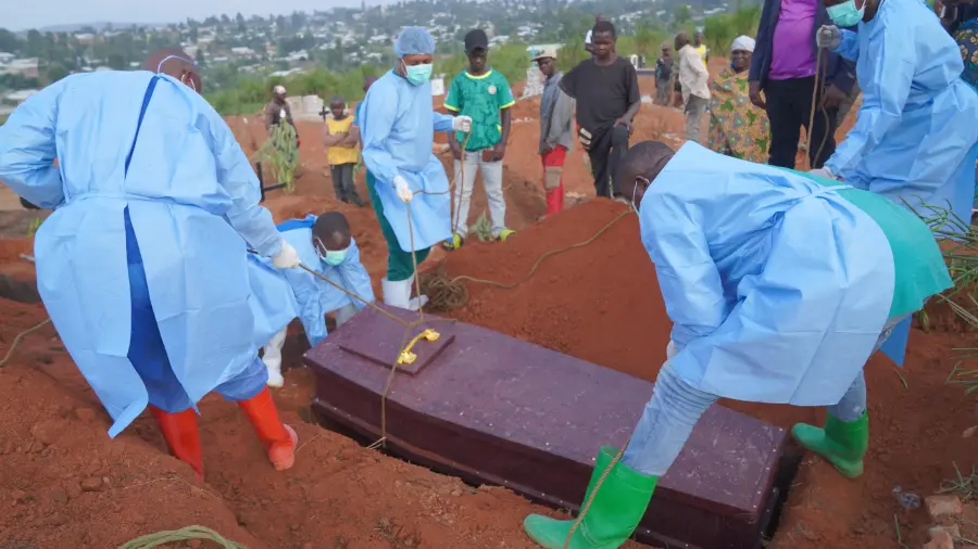 Varias personas con equipos de protección colocan un ataúd con los restos de Baudjo Baraka Jules, de 6 años y que murió de ébola, en una tumba, en Bunia, en la provincia de Ituri, República Democrática del Congo.