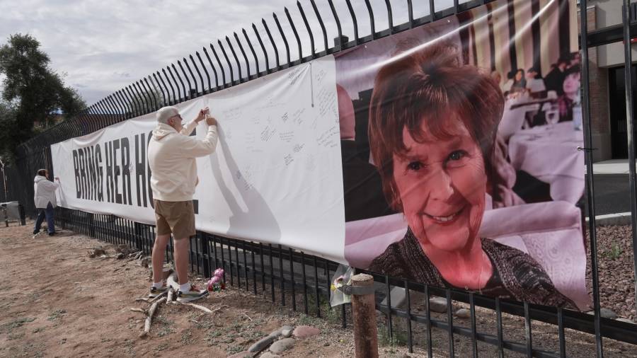 Jeff Robb, un residente de Seattle que pasa el invierno en Tucson, firma una pancarta en apoyo a Nancy Guthrie en Tucson, Arizona.