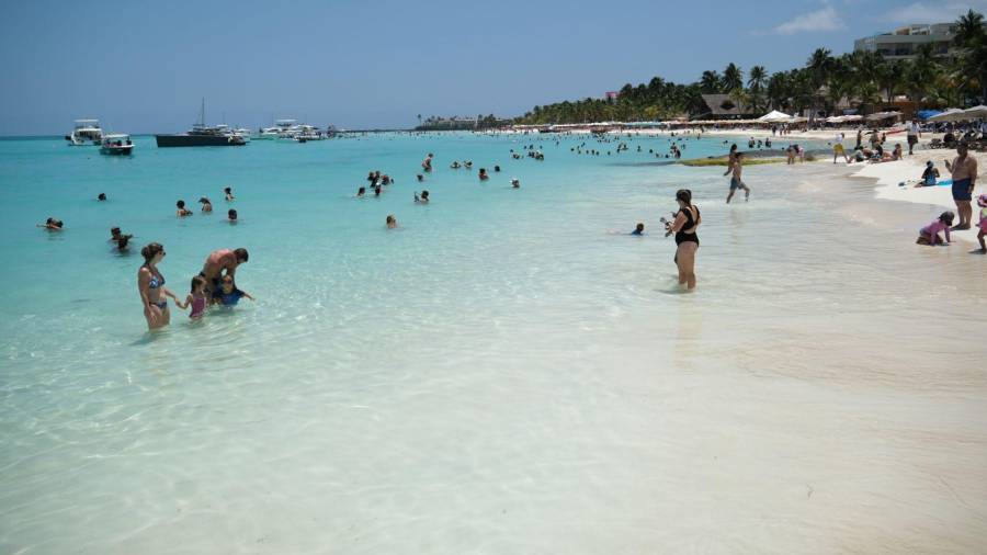Turistas nacionales e internacionales visitan las playas de Isla Mujeres al inicio de la temporada vacacional de verano, en un entorno libre de sargazo que favorece la llegada de visitantes.