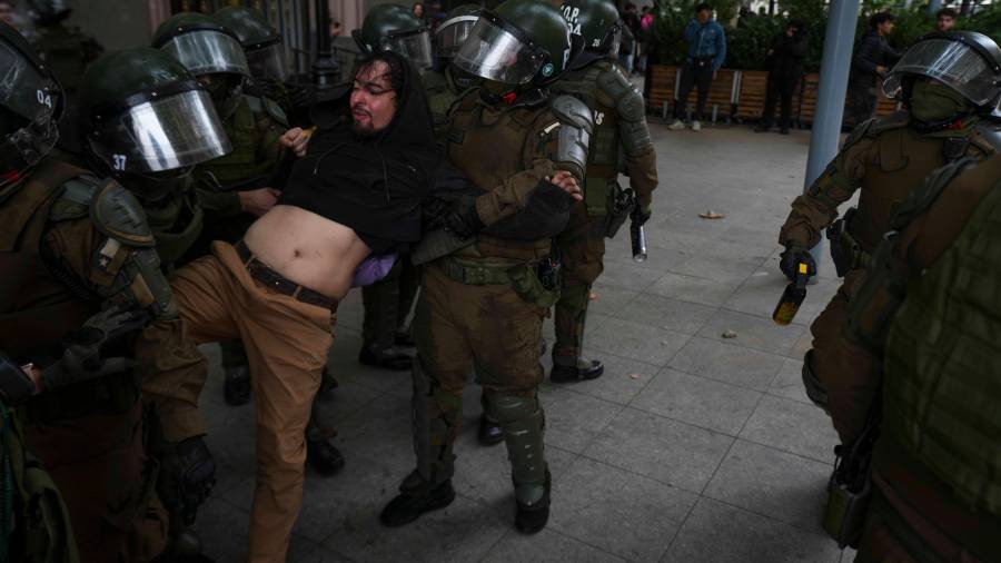 Policías antidisturbios detienen a un manifestante durante una marcha con motivo del Día Mundial del Agua, en la que se exigió mayor protección del medio ambiente y el bienestar animal.