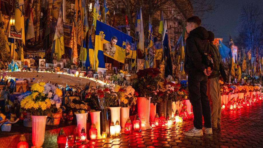 La gente enciende velas en la Plaza de la Independencia para conmemorar el cuarto aniversario de la invasión rusa de Ucrania, en Kiev, Ucrania