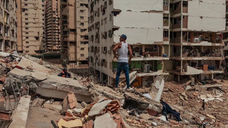 Un hombre observa las viviendas expuestas de edificios enteros que colapsaron completamente, mientras se teme que la crisis política y económica agrave la recuperación.