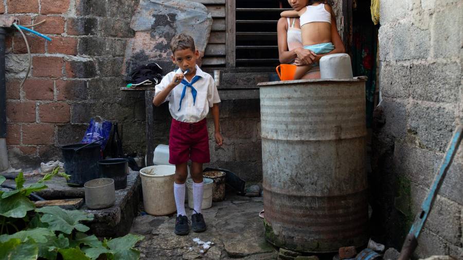 Analeidis Arias Matos supervisando a su hijo, Alejandro, mientras se alista para ir al colegio el mes pasado en Santiago de Cuba.