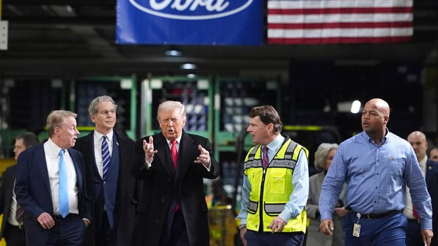 Trump hablando con Bill Ford (a la izquierda límite) y con Jim Farley (a la derecha, con chaleco amarillo). Al costado derecho del presidente de EU se observa al secretario del Tesoro, Scott Bessent.