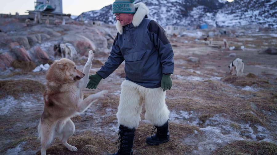 Jørgen Kristensen juega con su perro de trineo antes de hacer un recorrido en Ilulissat, Groenlandia.